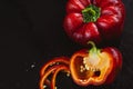 Fresh red bell pepper and slice on black background. Top view Tropical abstract background. Cloe up Pepper vegetaibles