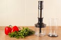 Fresh red bellpepper with herbs and a blender on kitchen table Royalty Free Stock Photo