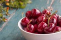 Fresh red cherries in a bowl, outdoors on a garden table