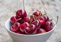 Fresh red cherries in a bowl, outdoors on a garden table