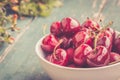 Fresh red cherries in a bowl, outdoors on a garden table