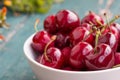 Fresh red cherries in a bowl, outdoors on a garden table