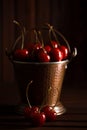 Fresh red cherries in copper bucket on dark wooden background Royalty Free Stock Photo