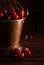 Fresh red cherries in copper bucket on dark wooden background Royalty Free Stock Photo