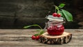Fresh red cherries fruit on wooden background. Jar of cherry jam and sour cherries. Berries cherry with syrup. Canned fruit. place Royalty Free Stock Photo