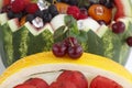 Fresh red cherries with green leaves, on the background of a fruit basket Royalty Free Stock Photo