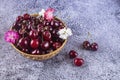 Fresh red cherries in a straw plate. Berries lie on the table.