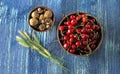 Fresh red cherries and walnuts in a bowl on a wooden blue table Royalty Free Stock Photo