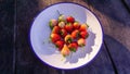 Fresh red cherries on a white plate laid on an old wooden floor, high vitamin healthy fruit