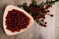 Fresh red cherries in a wooden plate on a wooden table. wooden plate on a wooden background.next to it is a cherry branch with che Royalty Free Stock Photo