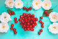 Fresh red cherry in a bowl on an old painted wooden table with fresh white roses as a bright colorful summer background for Royalty Free Stock Photo