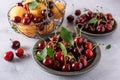 Fresh red cherry with green leaves in a gray ceramic plate. In the background, cherries and apricots in an iron basket and Royalty Free Stock Photo