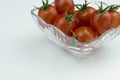 Fresh red cherry tomatoes with water drops in a glass bowl on a white background. Close up view, isolated tomatoes Royalty Free Stock Photo