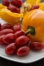 Red cherry tomatoes and yellow bell peppers close up Royalty Free Stock Photo