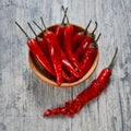 Wooden bowl with red hot chilli pepers on gray wooden background Royalty Free Stock Photo