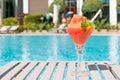 Fresh red cocktail with ice in glass on swimming pool. Tropical juice on luxury vacations. Concept summer holiday and travel Royalty Free Stock Photo