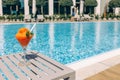 Fresh red cocktail with ice in glass on swimming pool. Tropical juice on luxury vacations. Concept summer holiday and travel Royalty Free Stock Photo