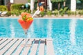 Fresh red cocktail with ice in glass on swimming pool. Tropical juice on luxury vacations. Concept summer holiday and travel Royalty Free Stock Photo