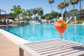 Fresh red cocktail with ice in glass on swimming pool. Tropical juice on luxury vacations. Concept summer holiday and Royalty Free Stock Photo