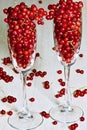 Fresh red currant berries pouring out of glassware on the table