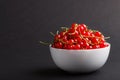 Fresh red currant in white bowl on black background. side view Royalty Free Stock Photo