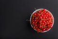 Fresh red currant in white bowl on black background. top view Royalty Free Stock Photo