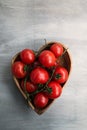 Fresh red delicious tomatoes in heart-shape plate