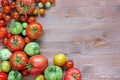 Fresh red and green tomatoes on a table at the left, on the righ Royalty Free Stock Photo