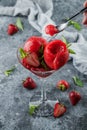 Fresh red ice cream with strawberries and mint in martini glass on light blue background. Summer dessert and sweet, close up. Royalty Free Stock Photo