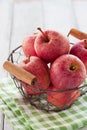 Fresh red juicy apples in a basket on a green textile on a wooden background Royalty Free Stock Photo