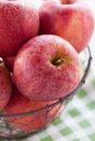 Fresh red juicy apples in a basket on a green textile on a wooden background Royalty Free Stock Photo