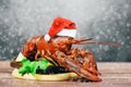 Fresh red lobster with christmas hat shellfish cooked in the seafood restaurant - Steamed lobster dinner food on wooden christmas