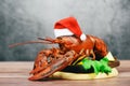 Fresh red lobster with christmas hat shellfish cooked in the seafood restaurant - Steamed lobster dinner food on wooden christmas Royalty Free Stock Photo