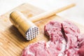 Fresh red meat and a hammer for beating meat Royalty Free Stock Photo