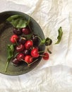 Fresh red cherries in a gray bowl, top view, on a white background