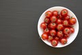 Fresh Red Organic Cherry Tomatoes in a Bowl on a black background, top view. Copy space Royalty Free Stock Photo