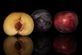 Fresh red plum isolated on black glass Royalty Free Stock Photo