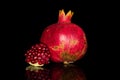 Fresh red pomergranate isolated on black glass Royalty Free Stock Photo