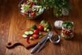Fresh red radish in wooden bowl among plates with vegetables, herbs and spicies, top view, selective focus. Royalty Free Stock Photo