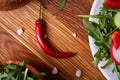 Fresh red radish in wooden bowl among plates with vegetables, herbs and spicies, top view, selective focus. Royalty Free Stock Photo