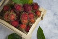 Fresh red rambutan fruit in a wooden box. Top view. Royalty Free Stock Photo