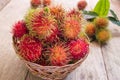 Fresh red rambutan sweet delicious fruit in basket on wood table. Tropical fruit tree, native to South - East Asia , cultivated in Royalty Free Stock Photo