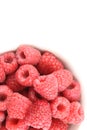 Fresh red raspberry fruits in a small white bowl