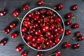 Fresh red ripe sweet cherry on plate on black slate background. Royalty Free Stock Photo