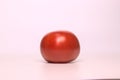 A fresh red ripe tomato isolated on pink background Royalty Free Stock Photo