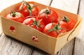 Fresh, red, ripe tomatoes in a box on a light Royalty Free Stock Photo