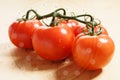 Fresh red ripe tomatoes on the vine on wooden table Royalty Free Stock Photo