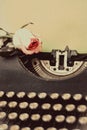 Fresh pink rose on vintage typewriter with blank page, retro toned Royalty Free Stock Photo