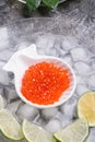 Fresh red salmon caviar. served with lime around ice. macro shot. Protein luxury delicacy healthy food