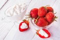 Fresh red strawberries with cream on the white wooden table.